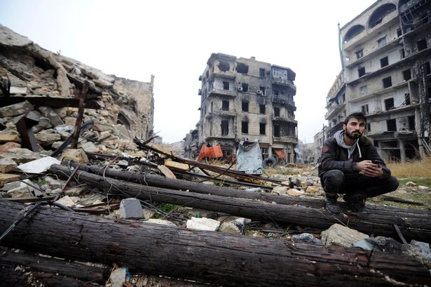 a-man-sits-amid-debris-near-umayyad-mosque-in-the-government-controlled-area-of-aleppo-during-a-me